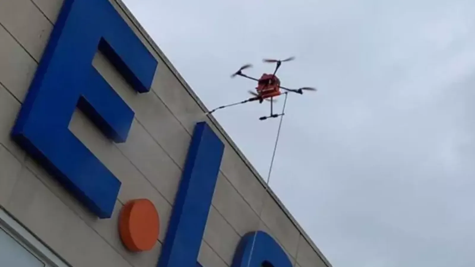 Dron myje okładzinę elewacyjną budynku centrum handlowego