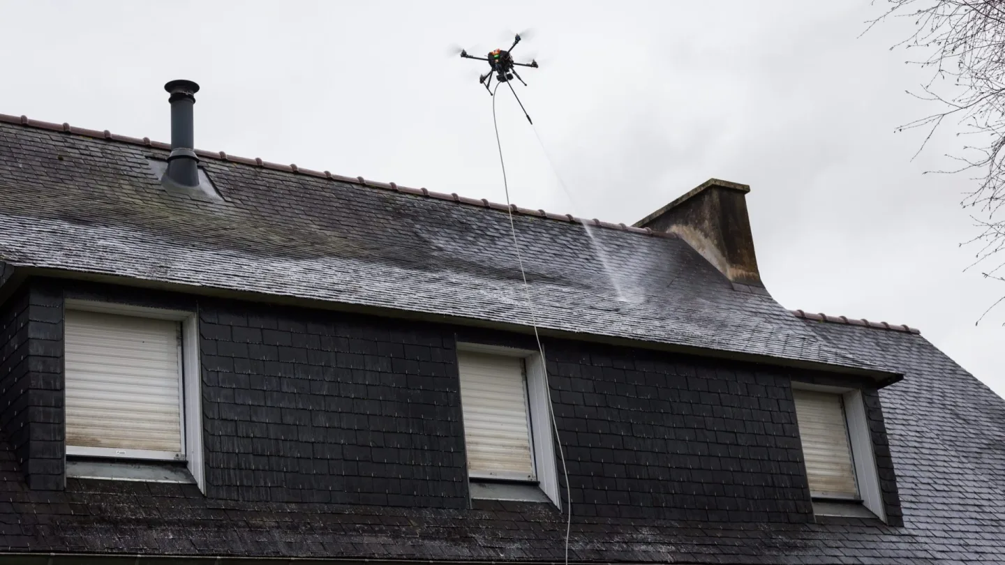 Dron natryskowy podczas czyszczenia dachu