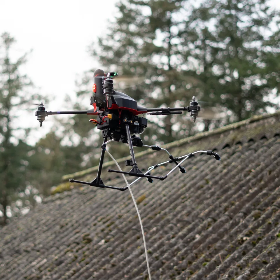 Dron czyszczący unoszący się bezpośrednio nad dachem